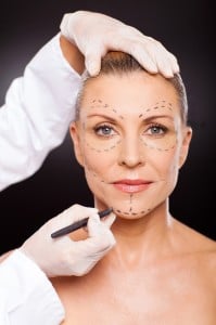 doctor marking senior woman face
